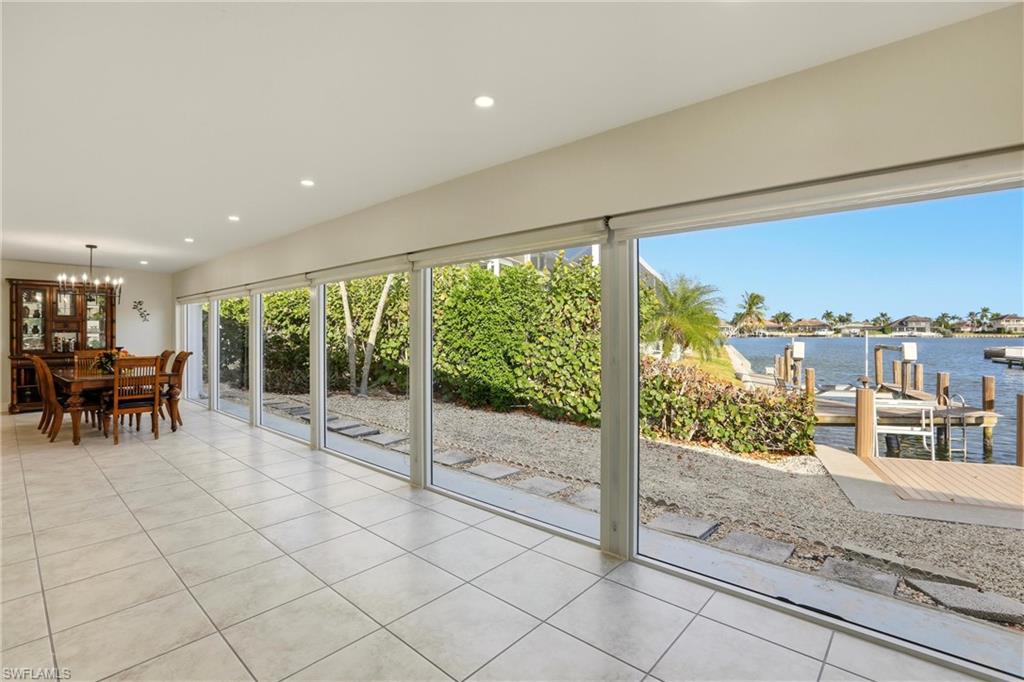 Sunroom / solarium featuring a water view and a chandelier