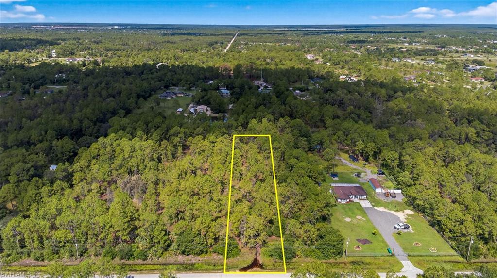 Aerial overview of property's location featuring property boundaries highlighted and a forest