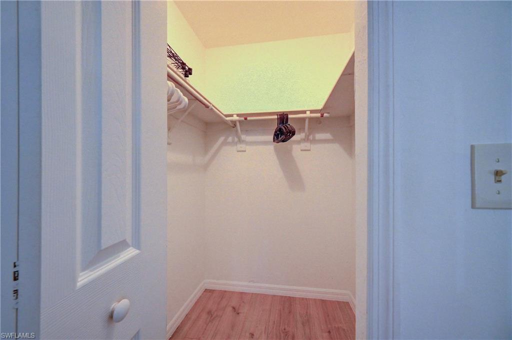 Walk-in closet featuring wood-finish flooring and built-in shelving