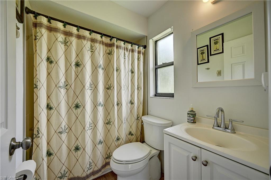 White vanity with a single basin, chrome faucet, and storage cabinetry