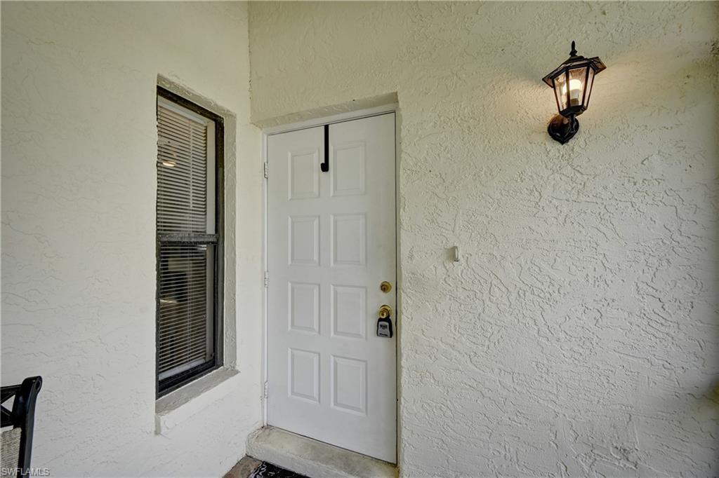White paneled entry door with a brass door handle and deadbolt
