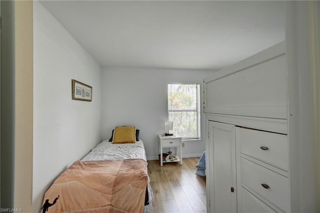 Recessed window, wood-finish flooring, white walls, and built-in white cabinetry