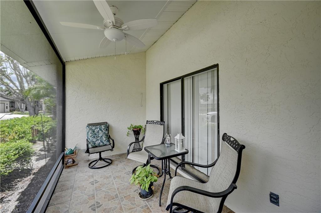 Screened outdoor living area with a ceiling fan, textured exterior wall, and sliding glass door