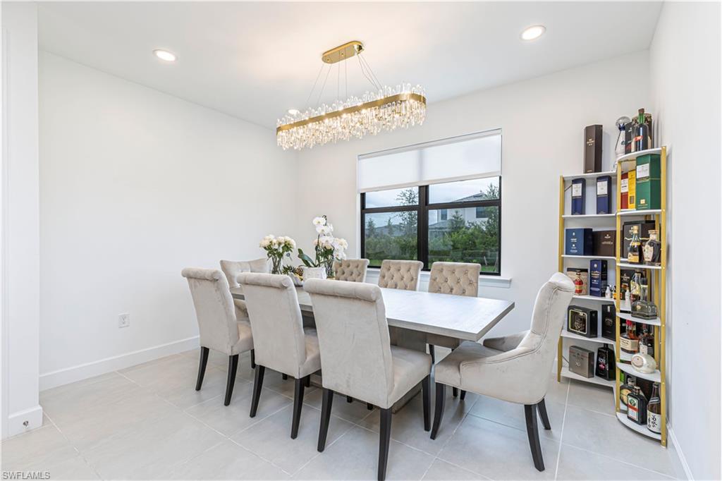 Dining space featuring a chandelier, recessed lighting, baseboards, and light tile patterned flooring