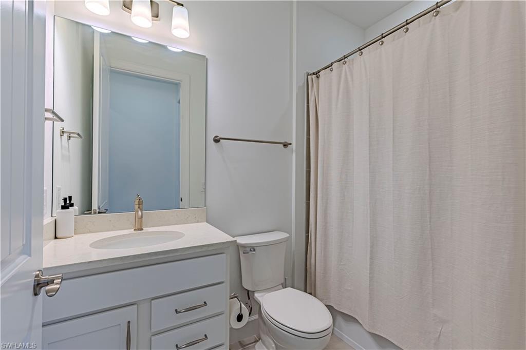 Full bath featuring vanity, toilet, and a shower with curtain