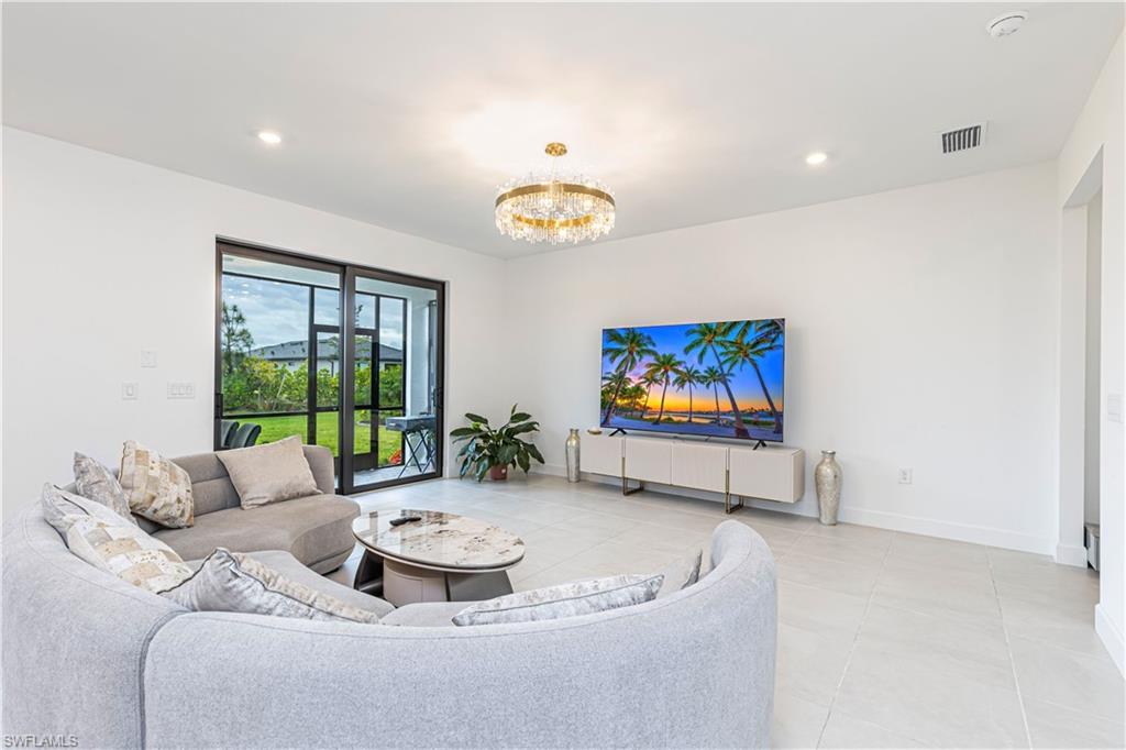 Living room featuring a chandelier, light tile patterned floors, baseboards, and recessed lighting