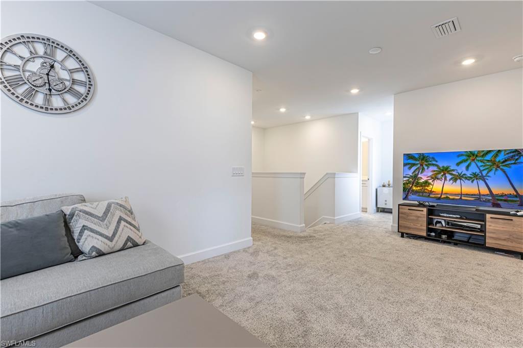 Unfurnished living room with carpet, baseboards, and recessed lighting