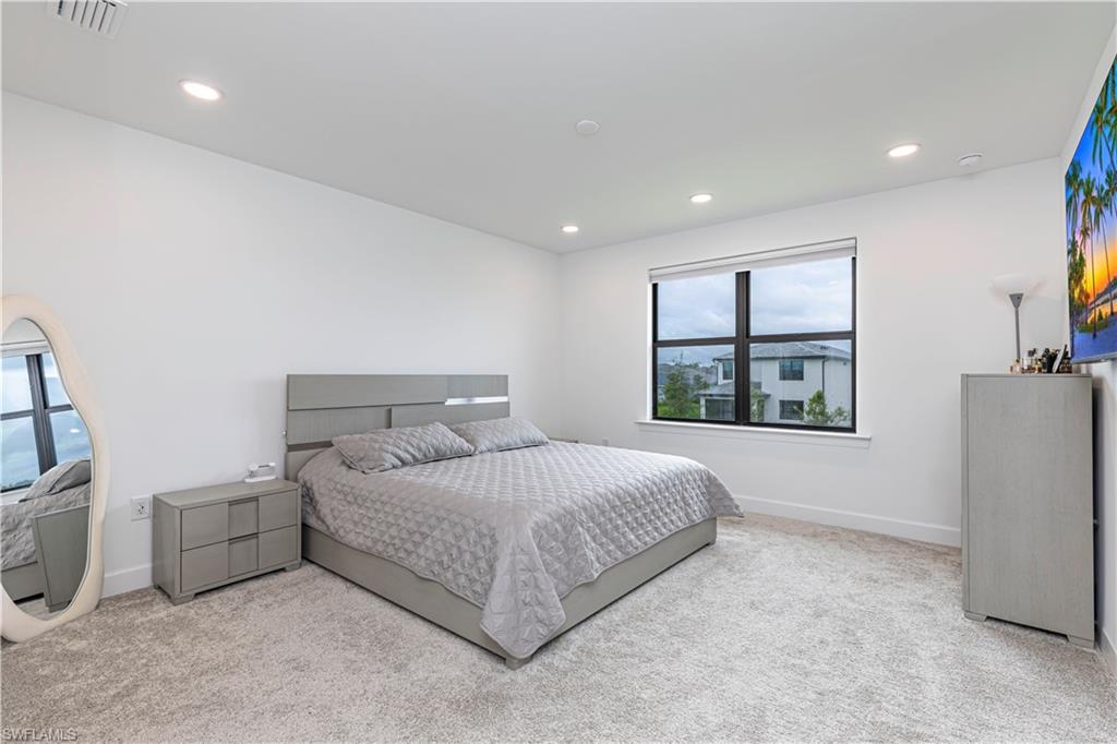 Carpeted bedroom with multiple windows, recessed lighting, and baseboards