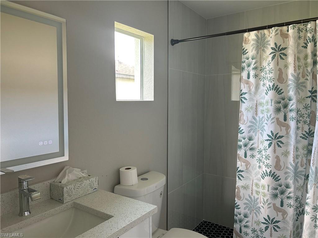 Bathroom featuring a vanity with an integrated rectangular sink, speckled countertop, and modern faucet