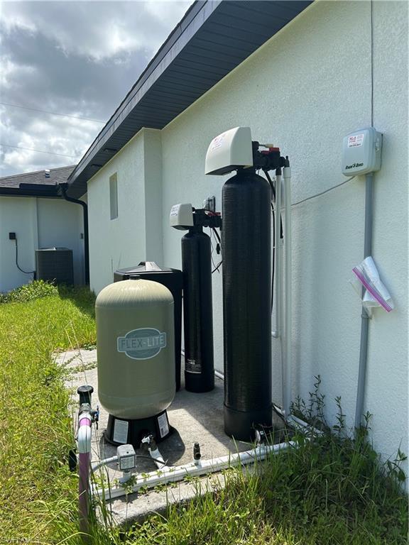 Whole house water filtration system featuring multiple tanks, plumbing, and control units