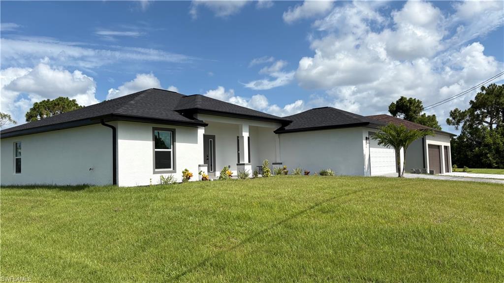 Contemporary single-story residence featuring a white stucco exterior, dark shingle roof, and black-framed windows