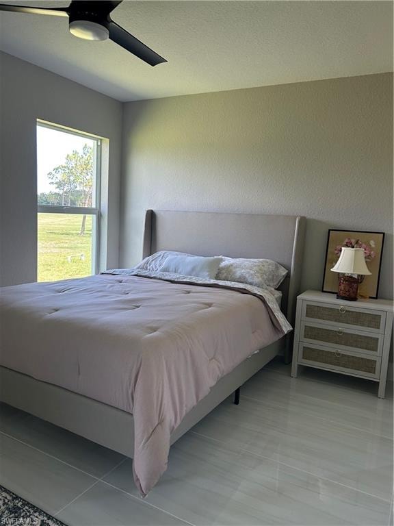 Room featuring a large window, light-toned walls, and tile flooring