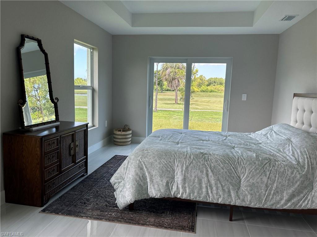 Bedroom featuring light gray walls and large format tile flooring