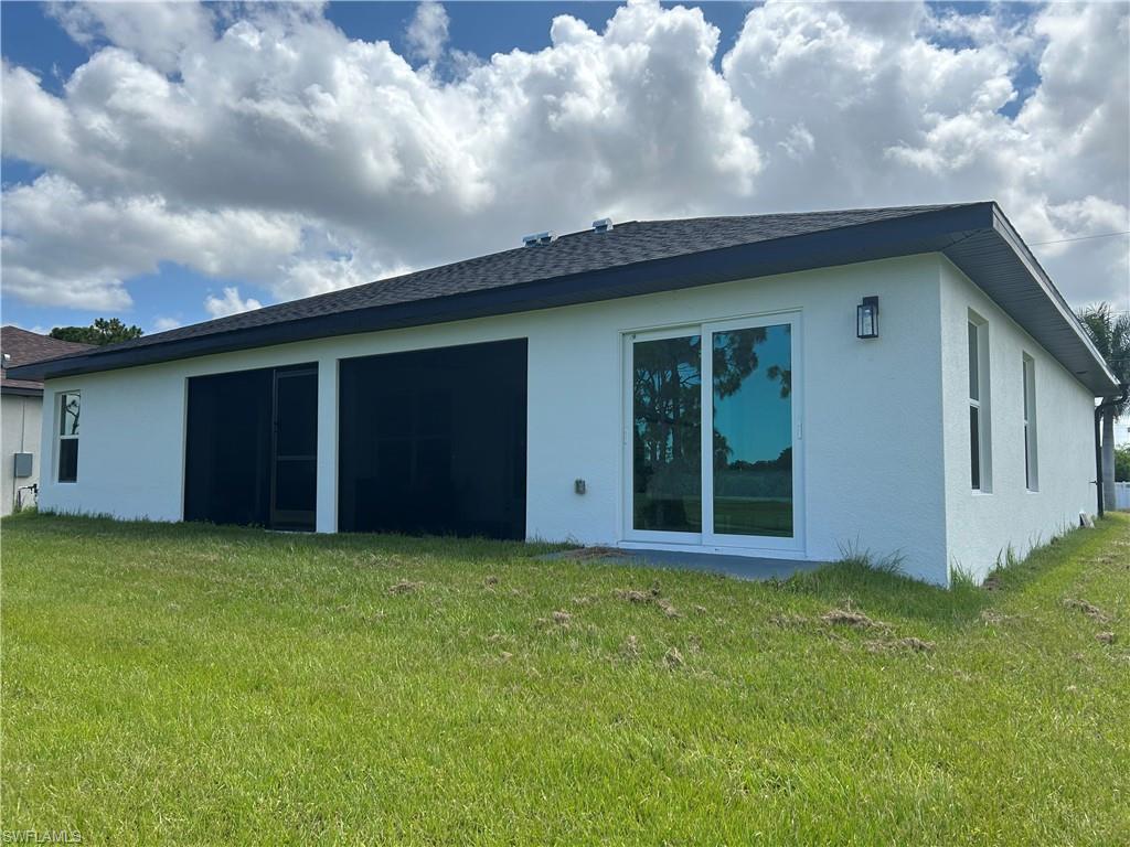 Contemporary exterior featuring white stucco finish, dark shingle roof, dual pane sliding glass doors, and a screened lanai with a concrete patio