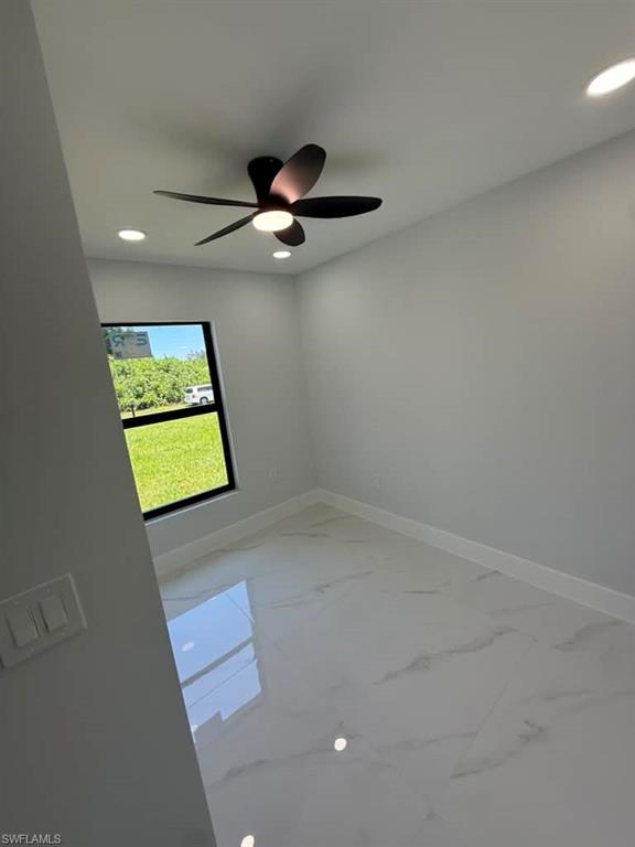 Interior room featuring a contemporary ceiling fan with integrated lighting, recessed lighting fixtures, a window with dark framing, light-colored walls, and large format polished tile flooring