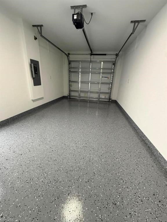Garage featuring a speckled epoxy floor finish and white painted walls