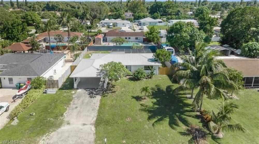 Single-story residence featuring a metal roof, an attached carport, and a partially fenced lot