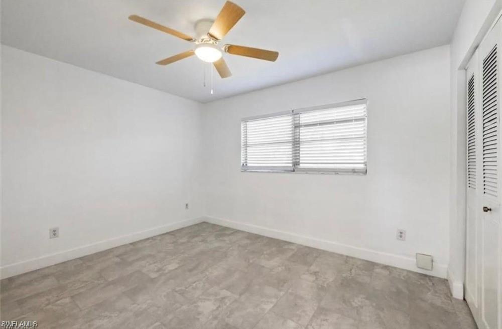 Room with wood-finish ceiling fan, window with horizontal blinds, and louvered bifold closet doors