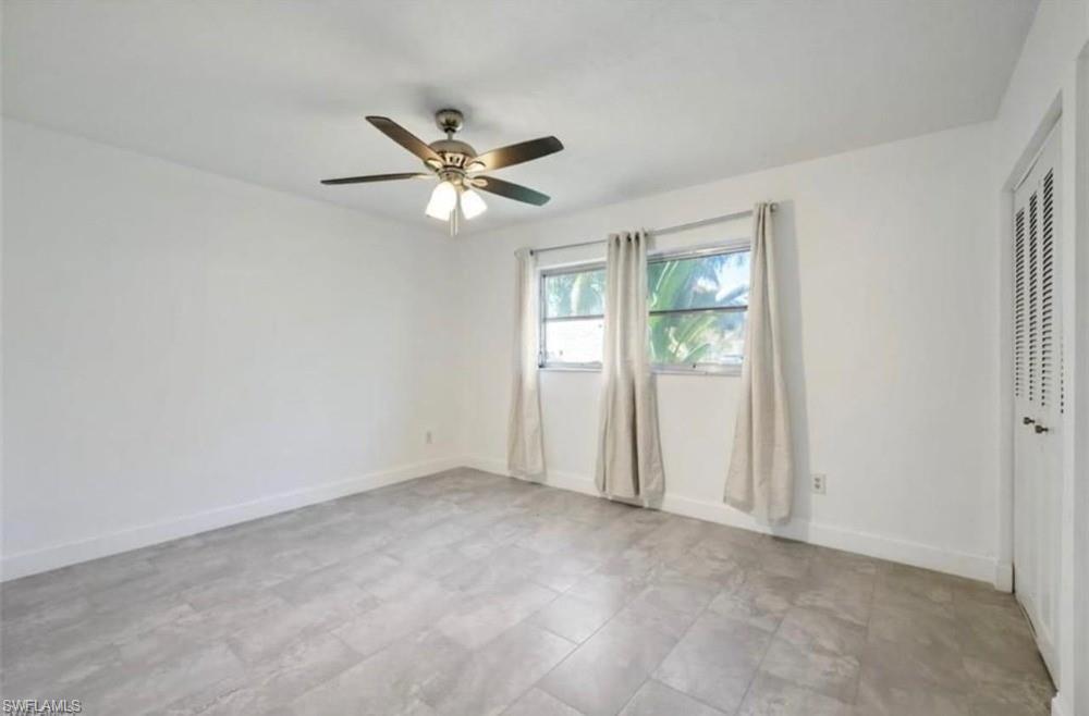 Room with light-toned tiled flooring, white walls, and a ceiling fan with integrated lighting