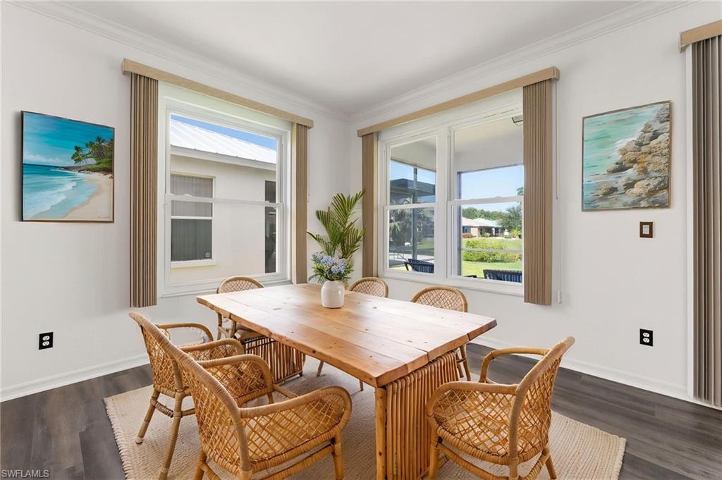 Dining space featuring white walls and crown molding
