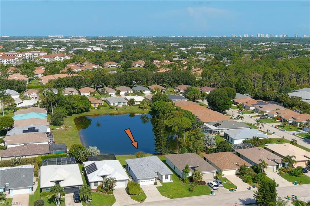 Lakeside property featuring mature landscaping and a well-maintained lawn