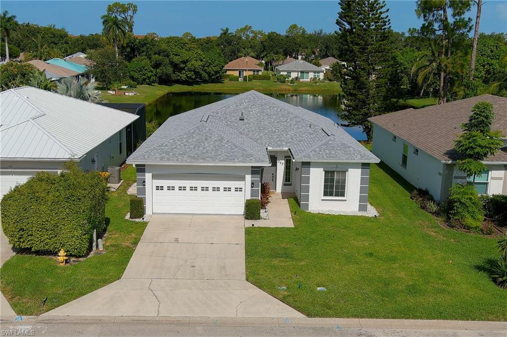 Single-story residence featuring a gray shingle roof, white exterior with gray accents, an attached two-car garage, and a concrete driveway