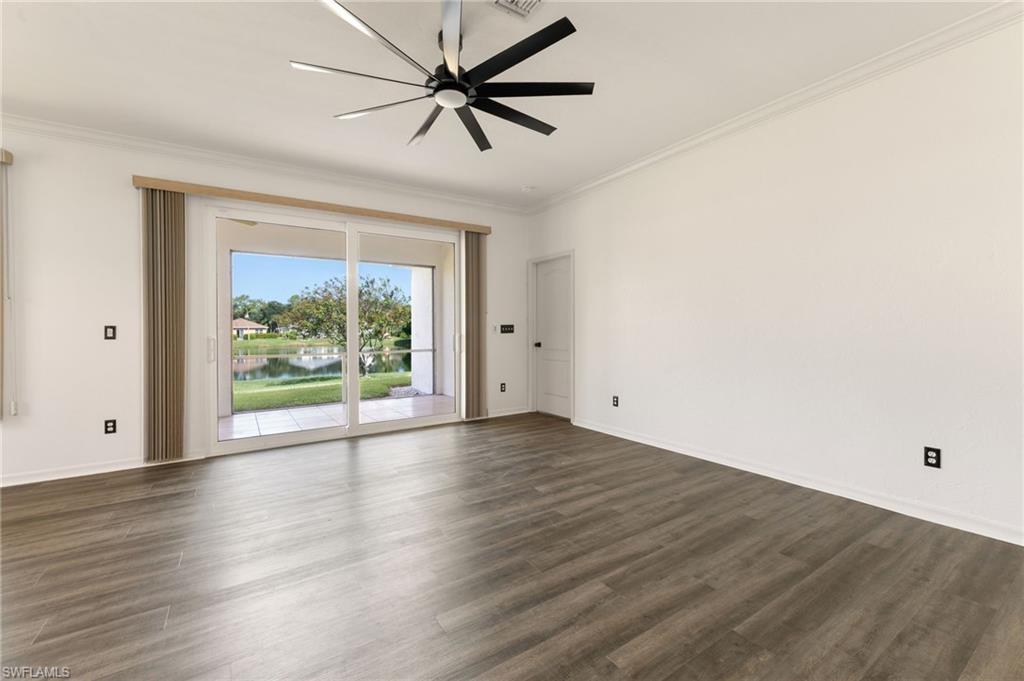 Spacious interior featuring wood-finish flooring, white walls, and crown molding