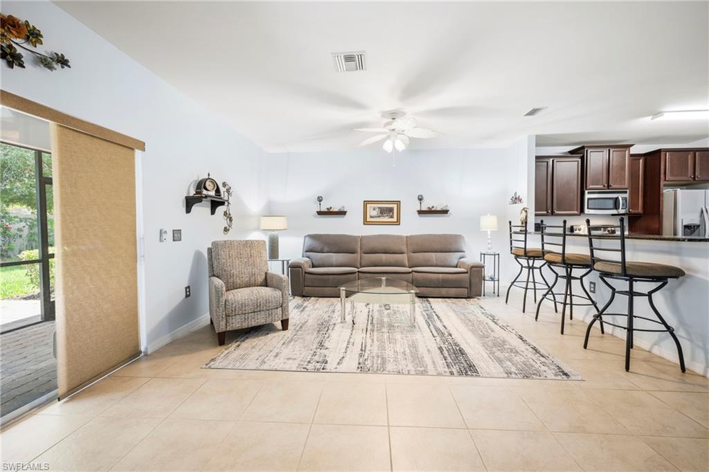 Expansive open-concept living area featuring large format tile flooring and a ceiling fan