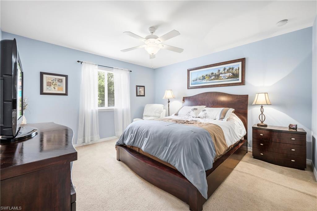 Room featuring a ceiling fan with integrated lighting, a window with horizontal blinds and sheer curtains, light-colored carpeting, and light blue wall tones