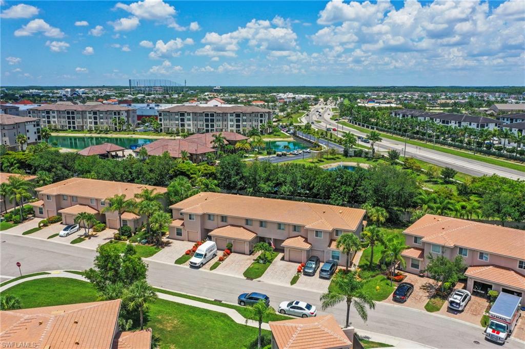 Aerial overview of a residential community featuring townhomes with attached garages and tile roofs
