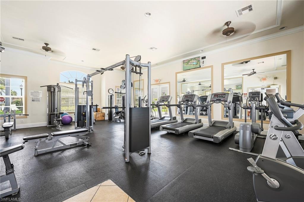 Fitness center featuring extensive exercise equipment on black rubber flooring