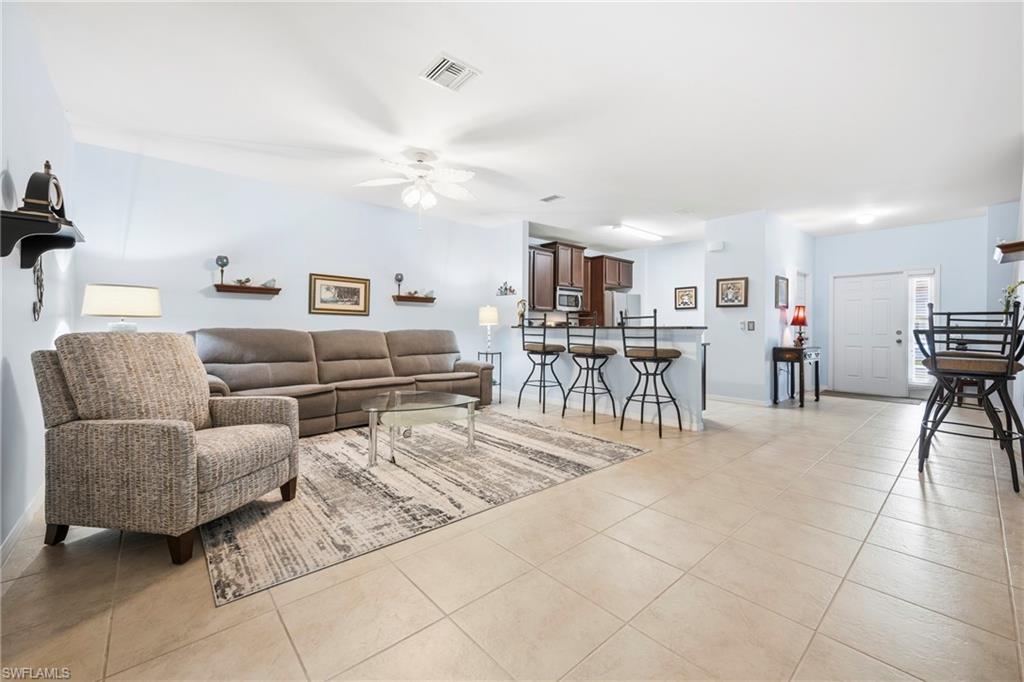 Open-concept living area featuring light-colored tile flooring throughout
