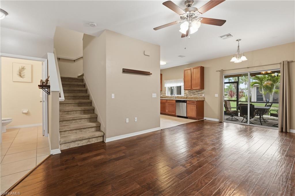 Spacious interior featuring wood-flooring, a ceiling fan, and a kitchen with wood cabinetry