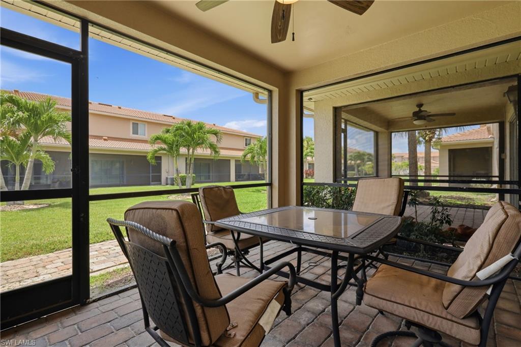 Screened lanai featuring brick paver flooring and ceiling fans
