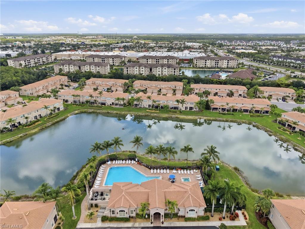 Community featuring a central lake, expansive outdoor pool, and multiple residential buildings