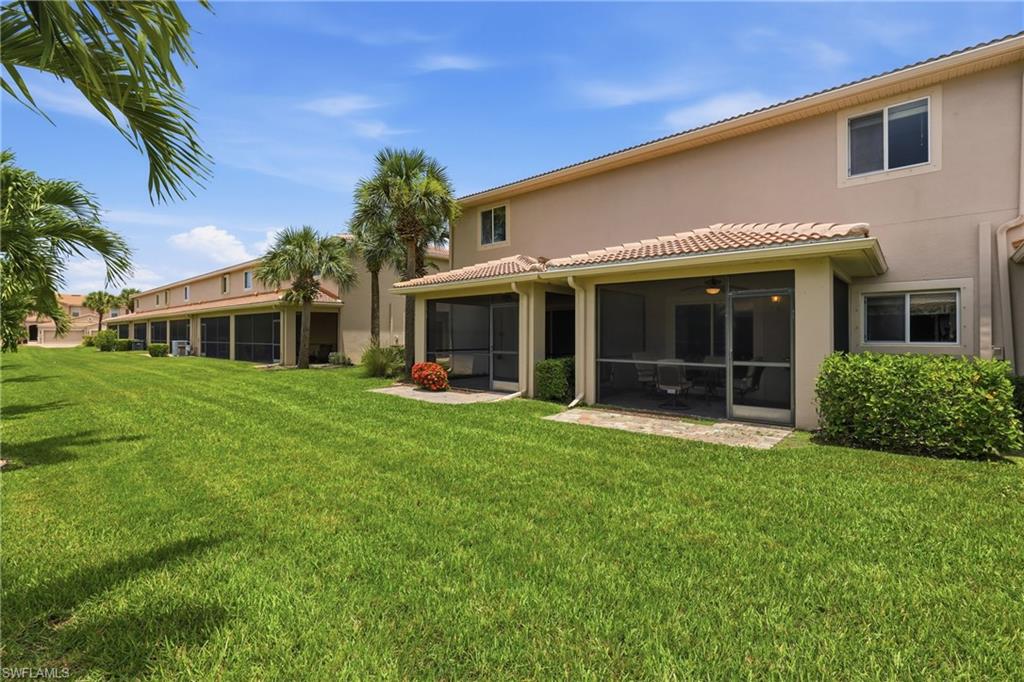 Expansive green space featuring screened patios, tile roofs, and mature palm trees