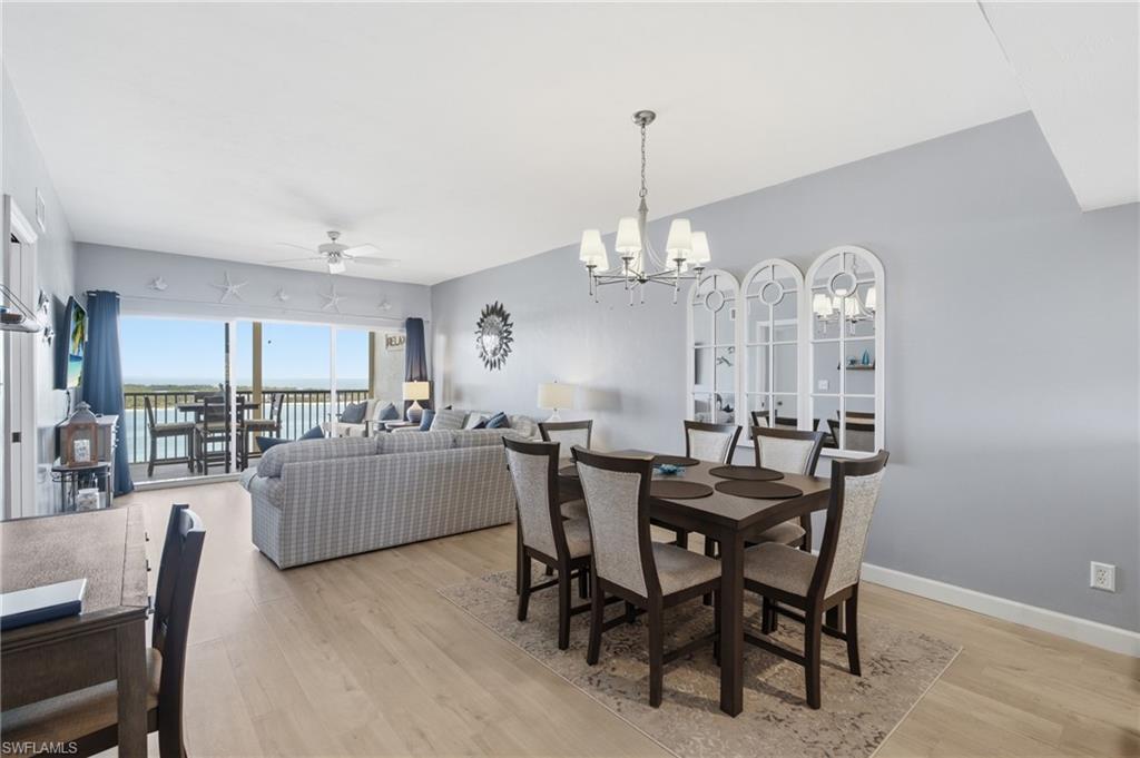 Open concept living area with light wood-finish flooring - Virtually Edited Image