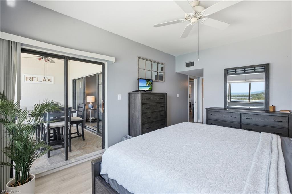Spacious room featuring light-toned walls, wood-finish flooring, and a ceiling fan - Virtually Edited Image