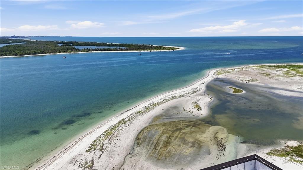 Expansive coastal landscape featuring clear blue waters, sandy shorelines, distant islands with lush green foliage, and open skies - Virtually Edited Image