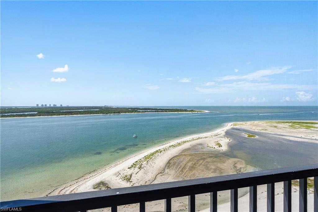 Expansive waterway and coastline views from a private balcony with metal railing - Virtually Edited Image