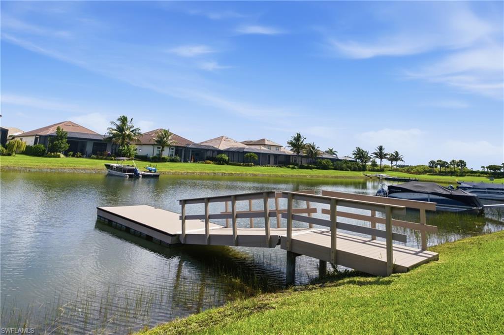 Waterfront property featuring a private dock and a spacious grassy bank leading to the water