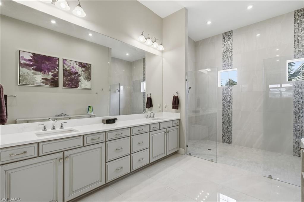 Bathroom featuring a light gray dual vanity with undermount sinks and chrome fixtures