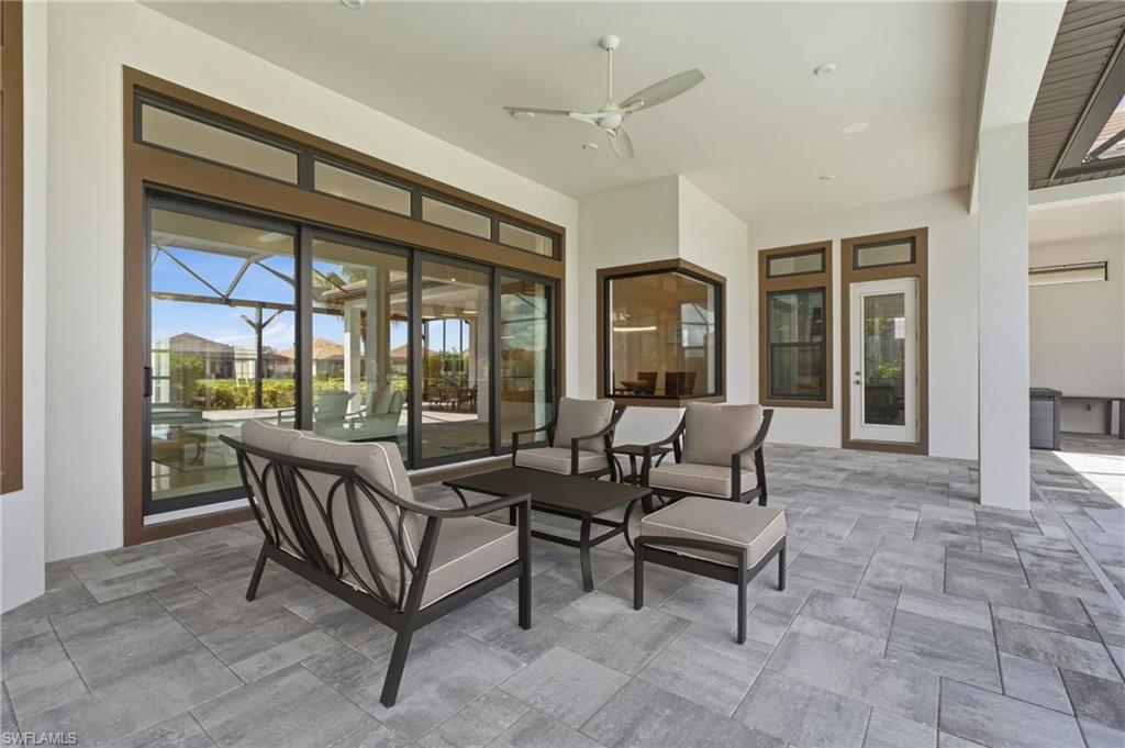 Expansive covered patio featuring large format tile flooring, a ceiling fan, and multiple access points