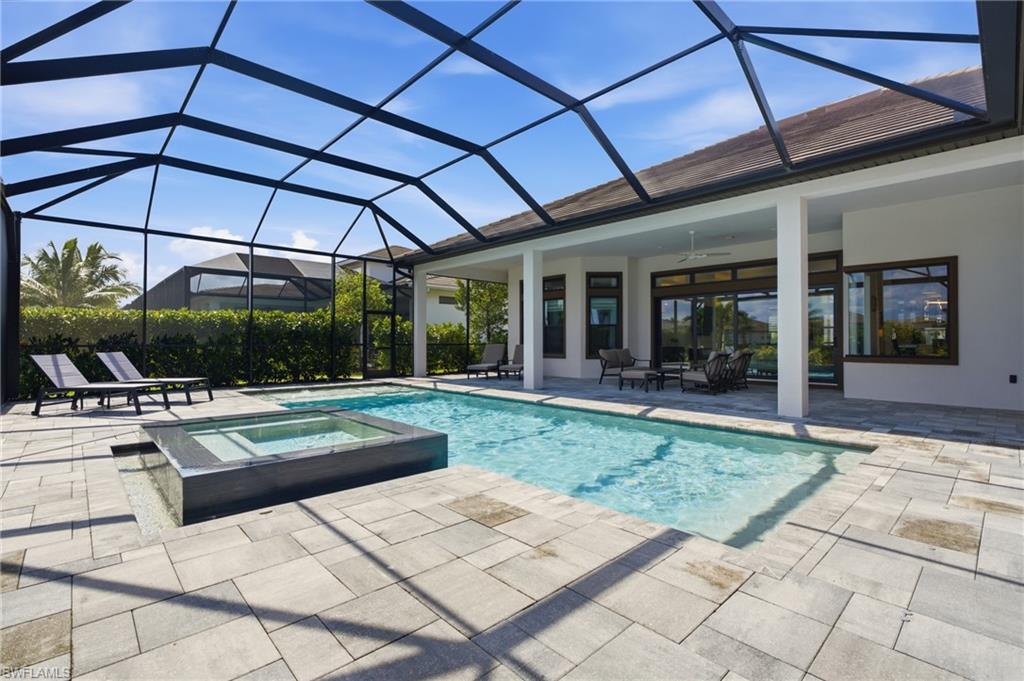 Screened lanai featuring a swimming pool and elevated spa with a water feature