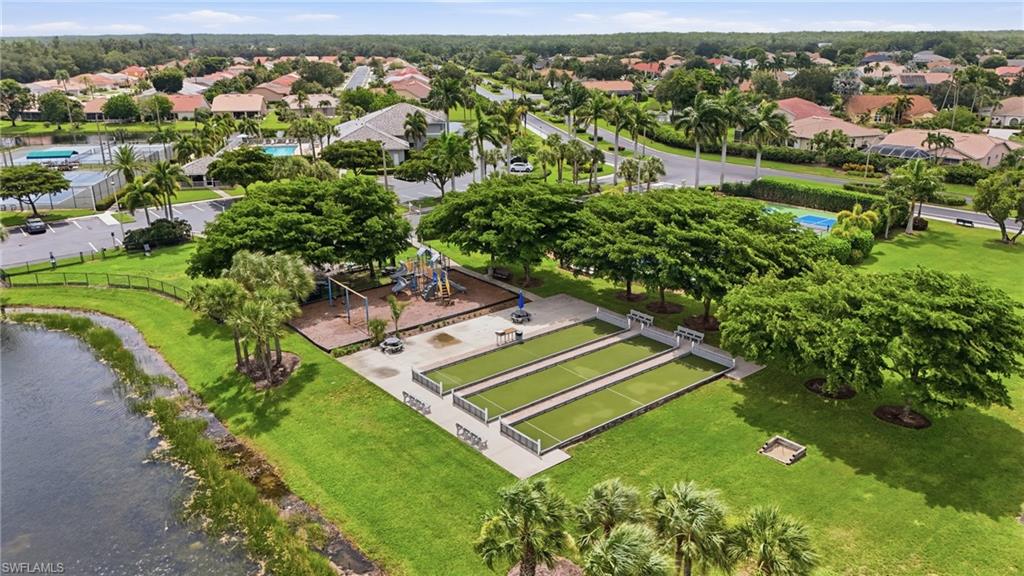 Community recreation area featuring bocce ball courts, playground structure, and expansive green space