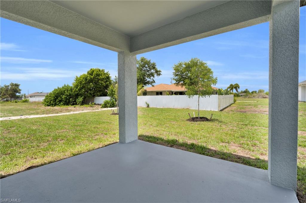 Covered patio with a smooth concrete surface, supported by stucco columns