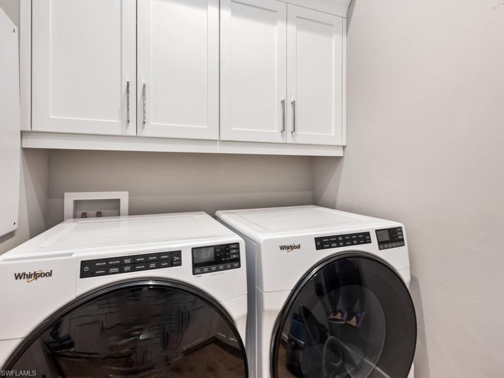 Washroom with cabinets and independent washer and dryer