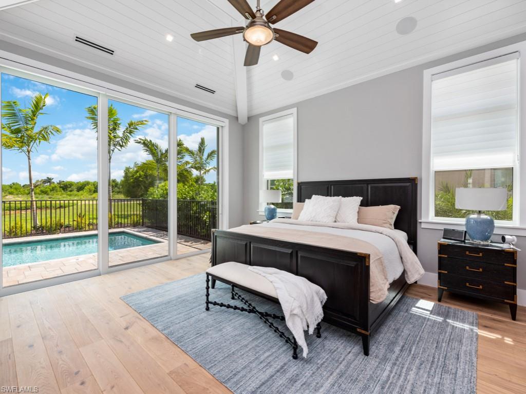 Bedroom with light hardwood / wood-style floors, multiple windows, and access to outside