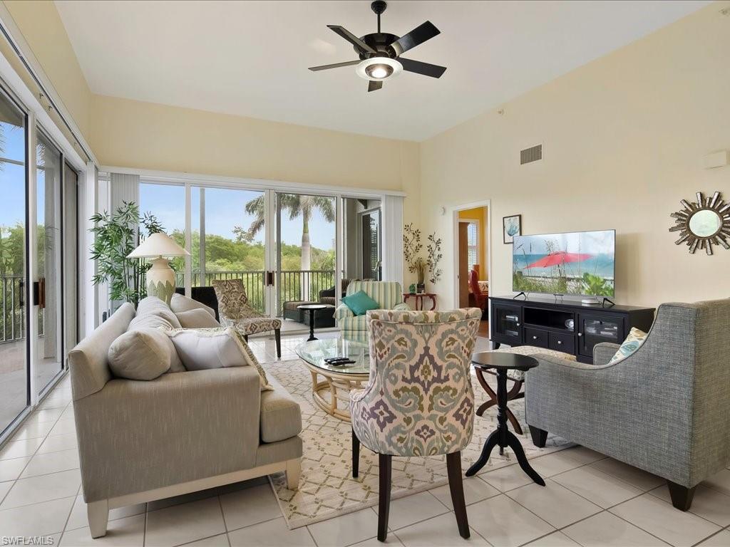 Living room with light tile patterned floors and a ceiling fan