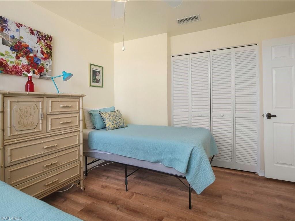 Bedroom with dark wood-style floors and a closet